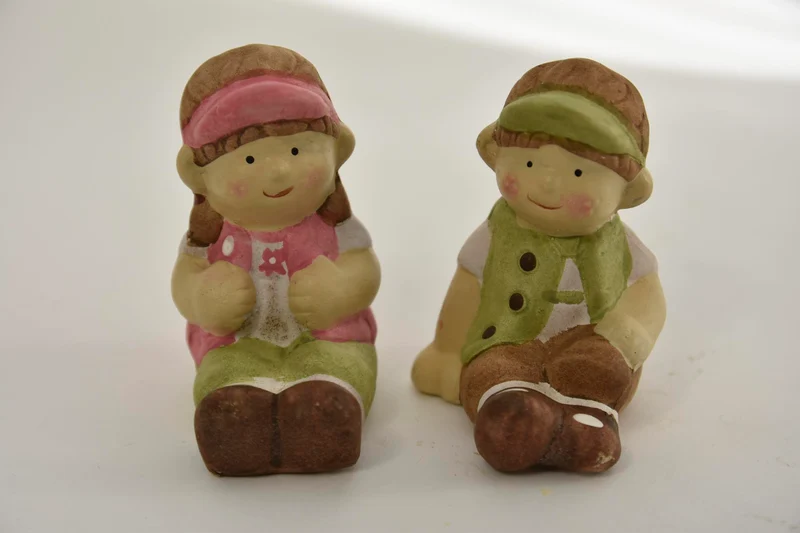 Kind mit Sitz 2 sortiert 7x6x8cm aus Keramik Grün und Rosa